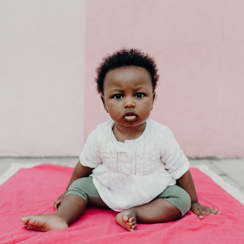 Rad Royals Toddler Collection_toddler sitting on pink blanket with natural hair